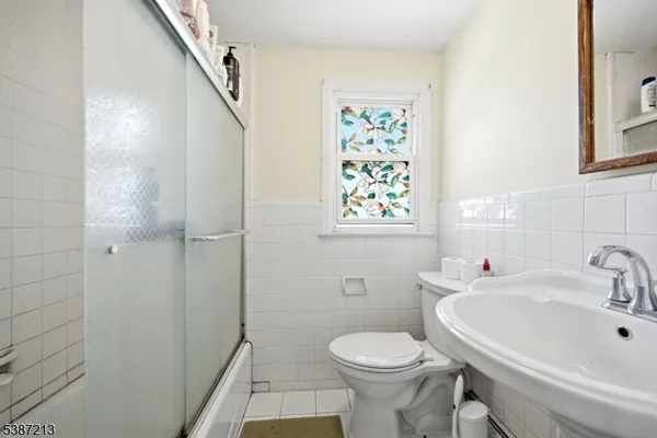 a bathroom with a sink and mirror with toilet