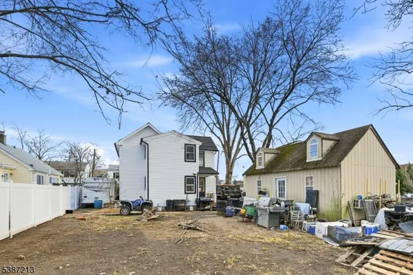 a view of a house with a barbeque stove and a large tree