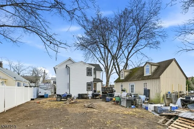 a view of a house with a barbeque stove and a large tree