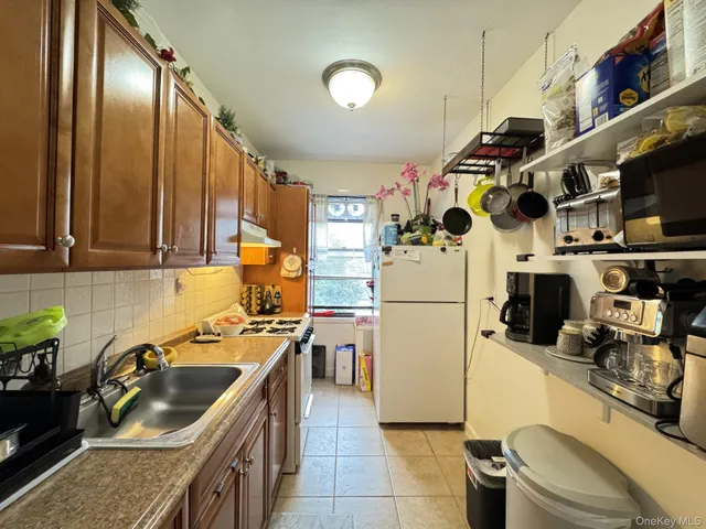 a kitchen with stainless steel appliances granite countertop a sink a stove and a refrigerator