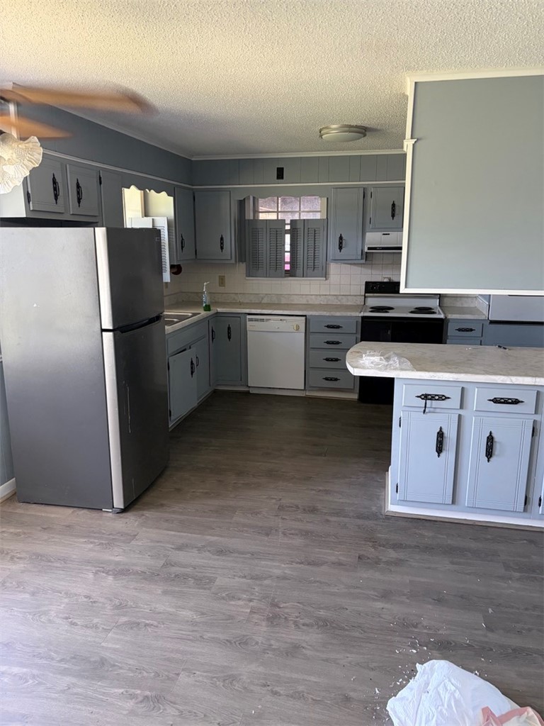 618 Madden Road Jacksonville, AR 72076 - Photo 24 of 34 Kitchen featuring gray cabinetry, light countertops, wood-finish flooring, and white tile backsplash