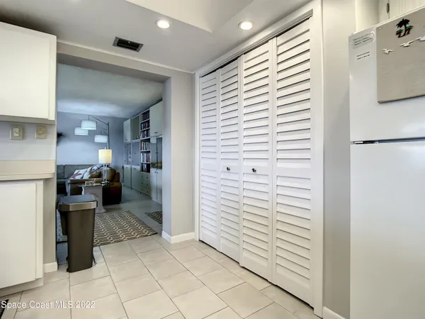 a view of a hallway with kitchen and entryway
