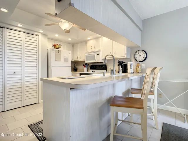 a kitchen with a table chairs refrigerator and cabinets
