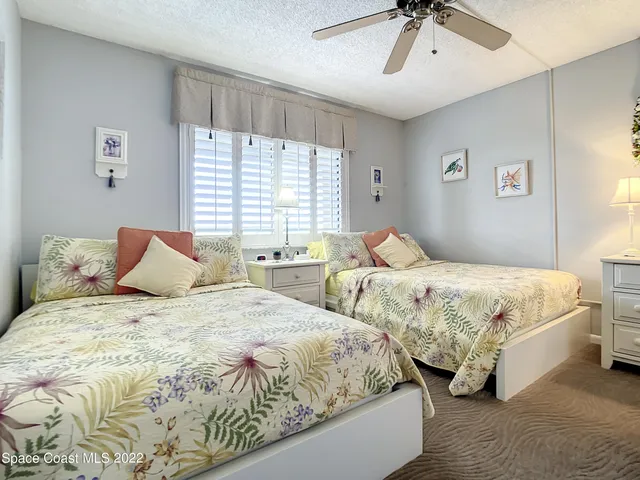 a bedroom with two beds and painting on the wall
