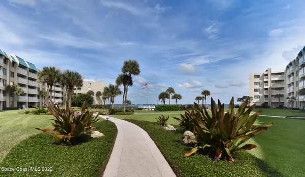 a view of a garden with a building in the background