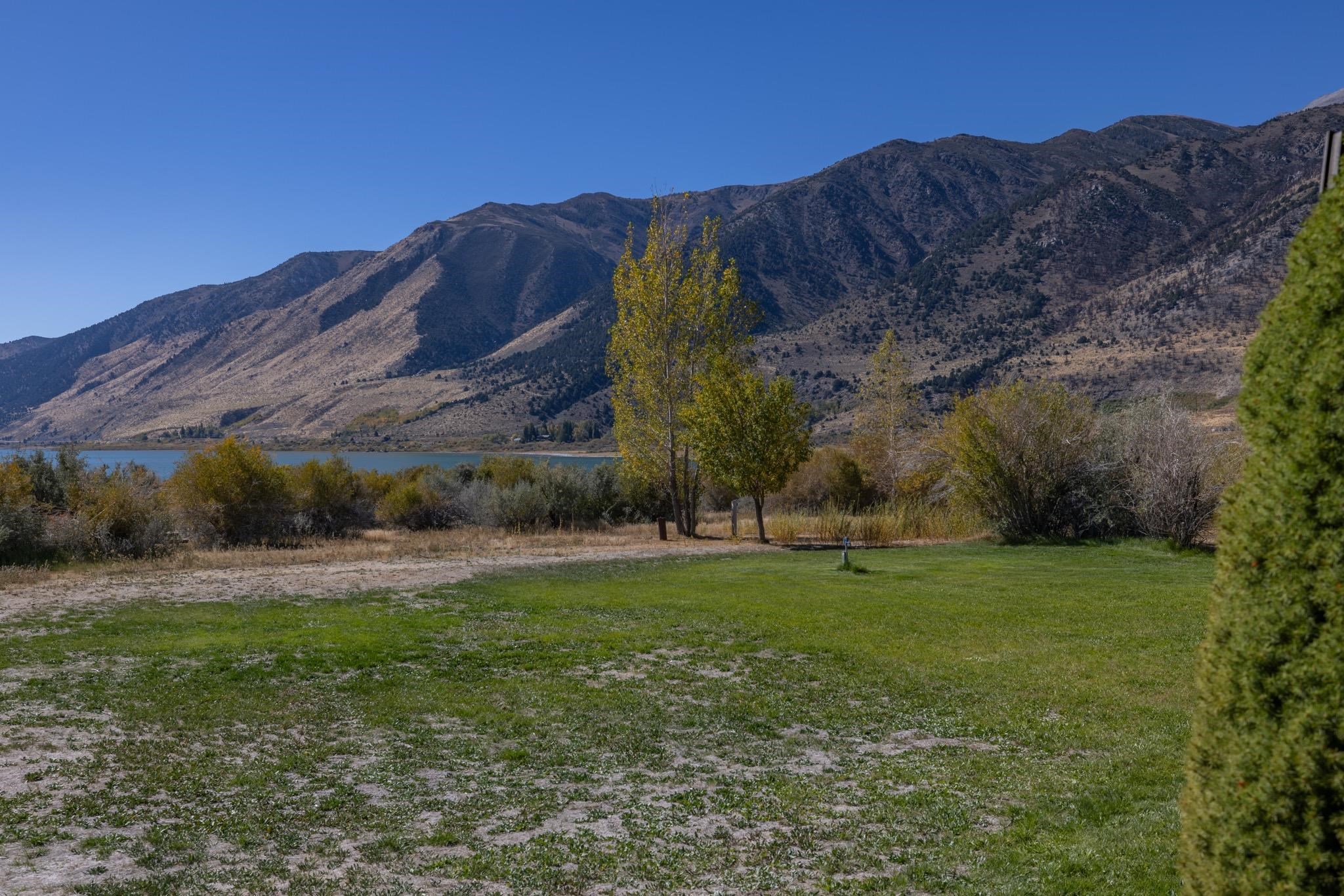790 Cemetery Road Lee Vining, CA 93541 - Photo 31 of 39 Expansive green lawn with a backdrop of a tranquil lake and distant mountains