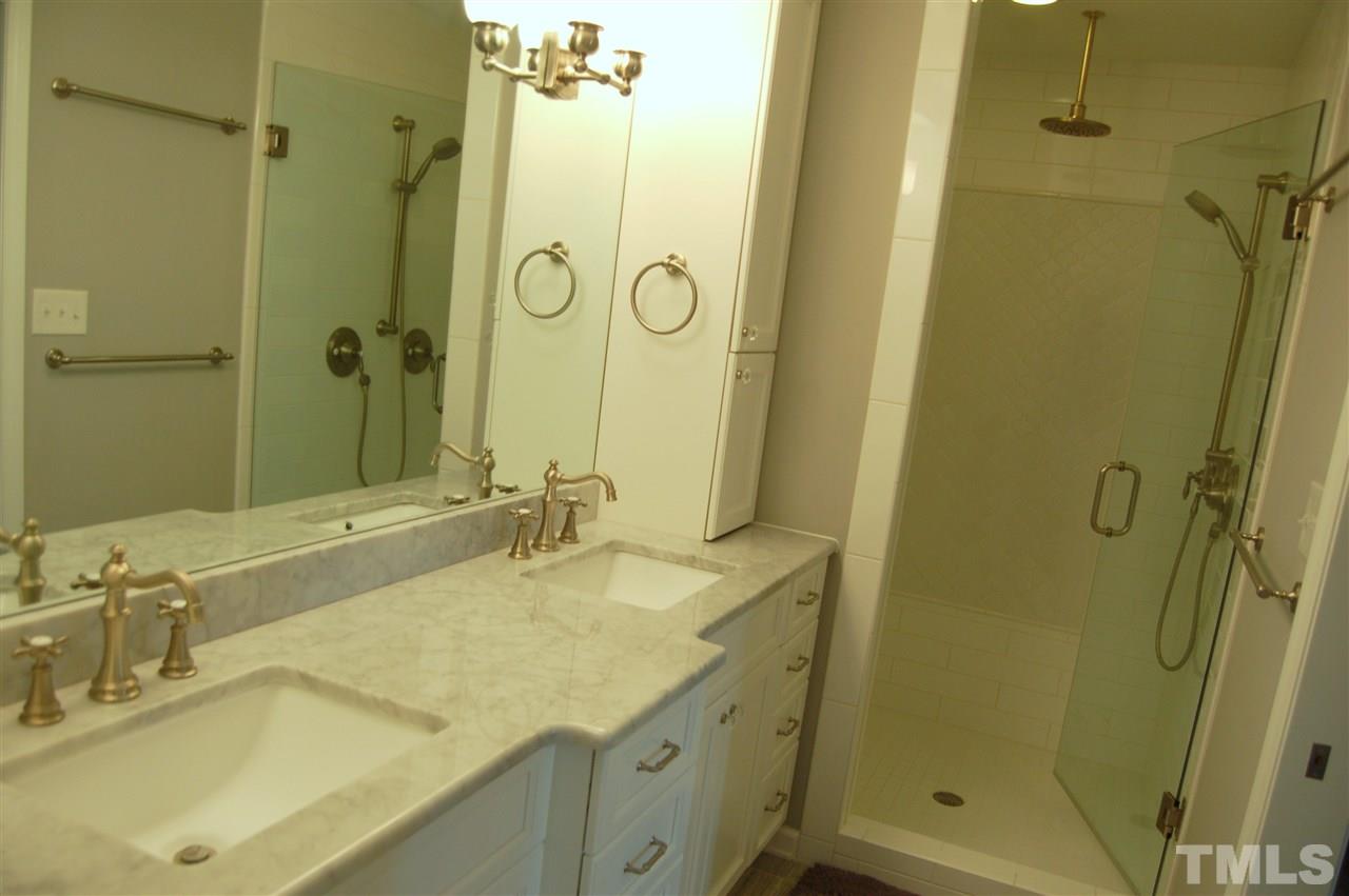 300 Barclay Road Durham, NC 27712 - Photo 17 of 25 a bathroom with a shower sink and mirror