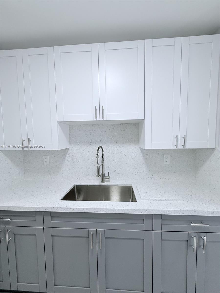 956 West 68th Street Hialeah, FL 33014 - Photo 13 of 21 a kitchen with white cabinets and a sink