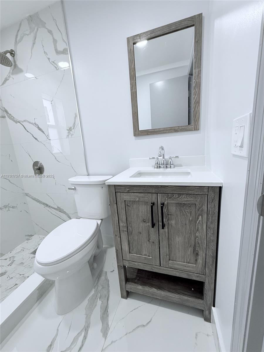 956 West 68th Street Hialeah, FL 33014 - Photo 7 of 21 a bathroom with a toilet sink and mirror