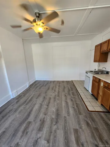 a view of a room with wooden floor and flat screen tv