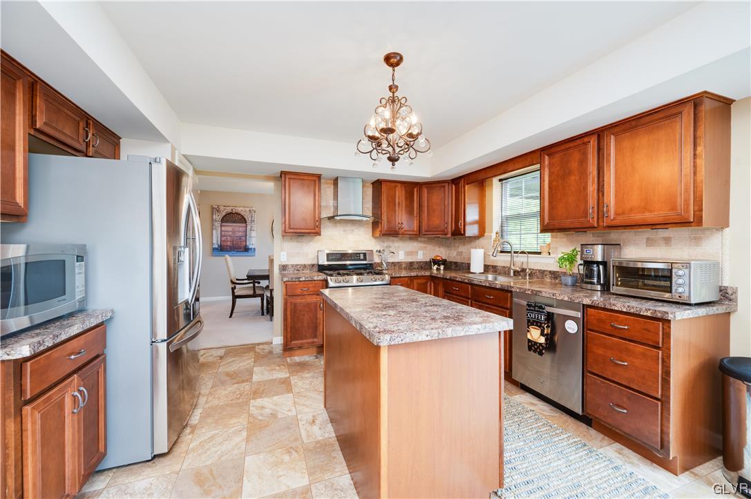 238 Longview Drive Reading, PA 19608 - Photo 12 of 43 a kitchen with stainless steel appliances granite countertop a stove top oven a sink dishwasher a dining table and chairs with wooden floor