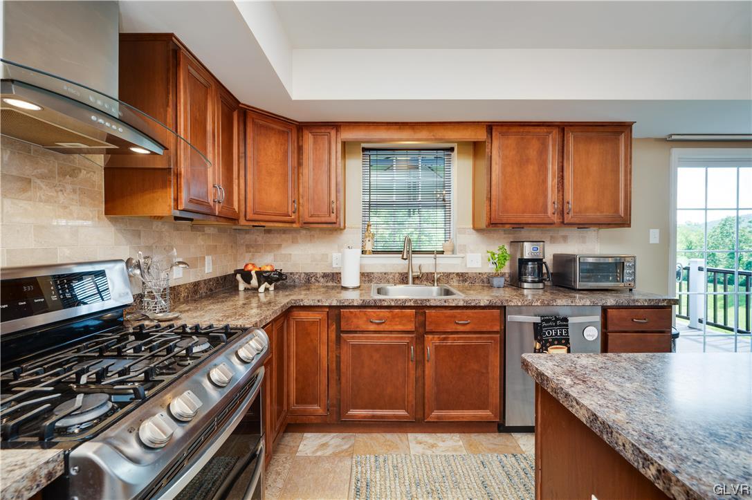 238 Longview Drive Reading, PA 19608 - Photo 16 of 43 a kitchen with stainless steel appliances granite countertop a stove a sink dishwasher and cabinets with wooden floor