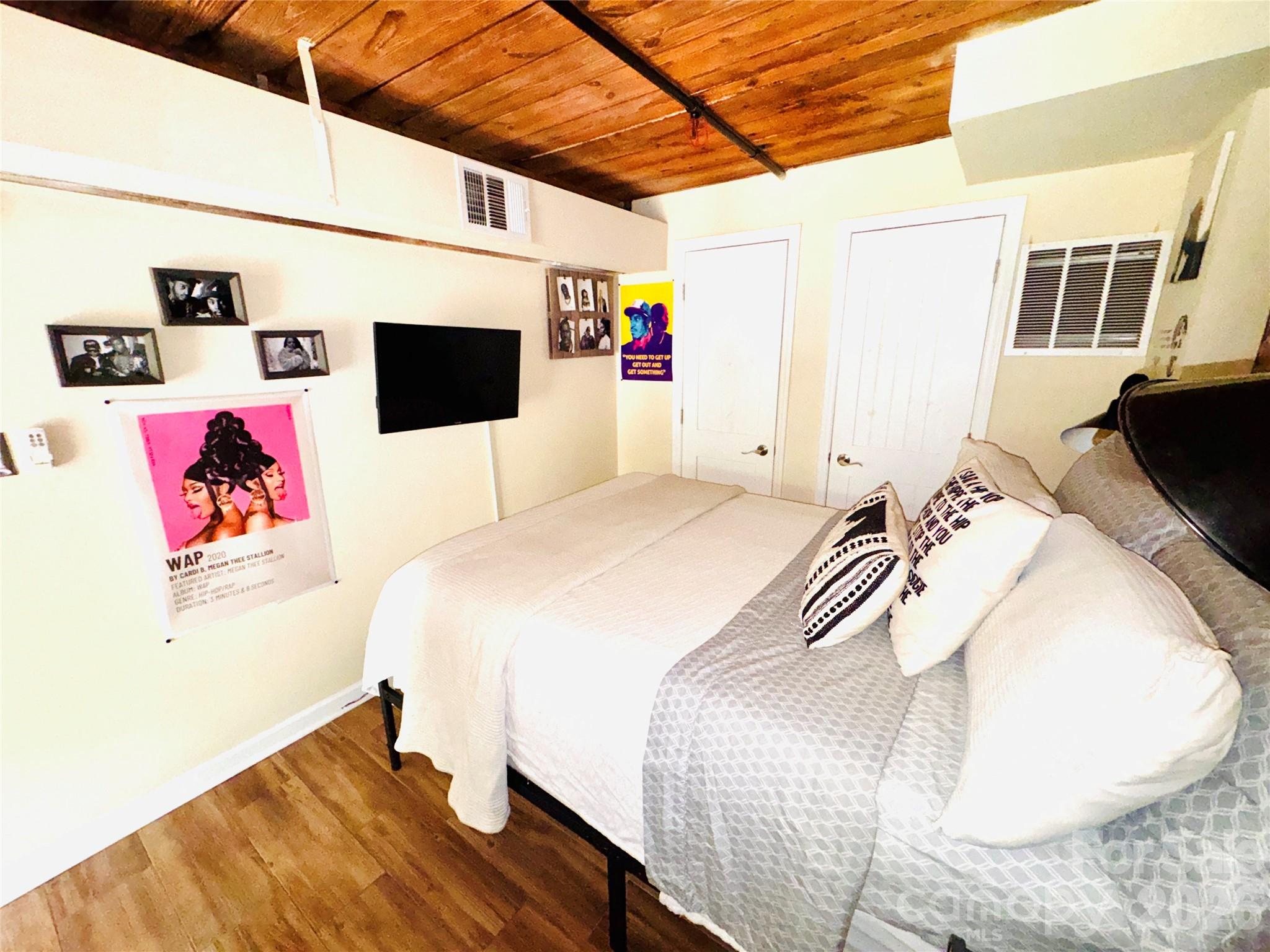 201 South Hoskins Road, Unit 132 Charlotte, NC 28208 - Photo 15 of 20 a bedroom with a bed and a flat screen tv