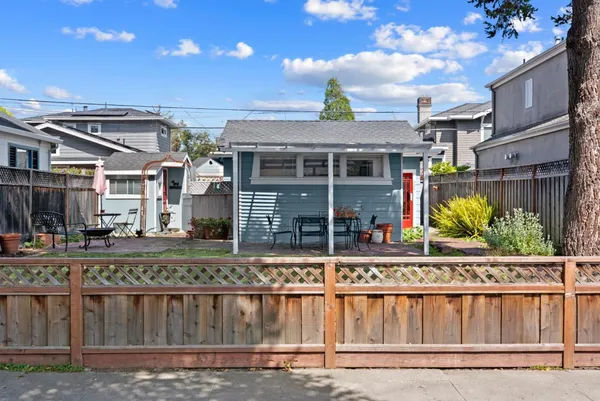 a view of a brick house with a wooden fence