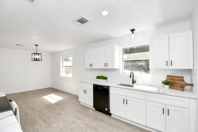 a kitchen with a sink cabinets and window