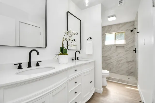 a bathroom with a double vanity sink and a mirror