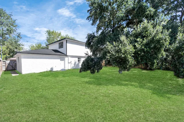 a view of a yard with an tree and wooden fence