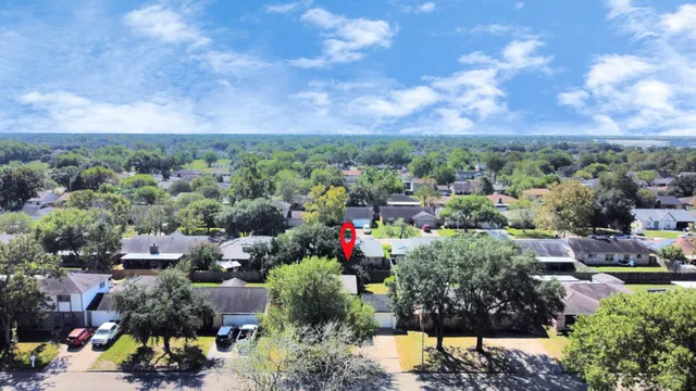 an aerial view of a house with a garden and a large tree