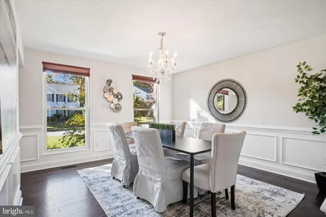 a dining room with furniture a chandelier and wooden floor