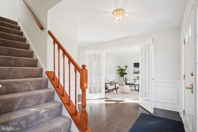 a living room with furniture a dining table wooden floor and a large window