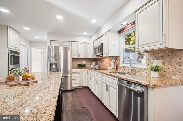 a view of a kitchen with a refrigerator and a stove top oven