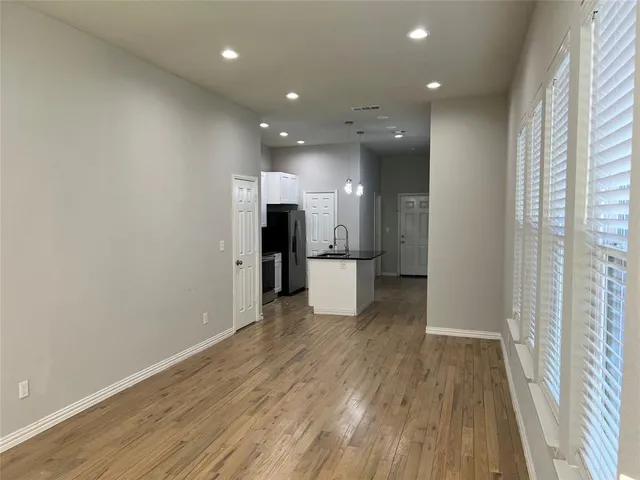 a view of a big room with wooden floor and a window