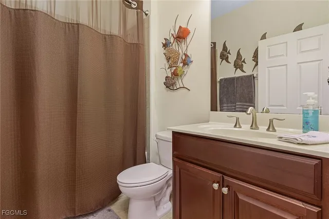 a bathroom with a sink vanity mirror and toilet