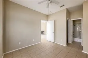 an empty room with a chandelier fan and glass door