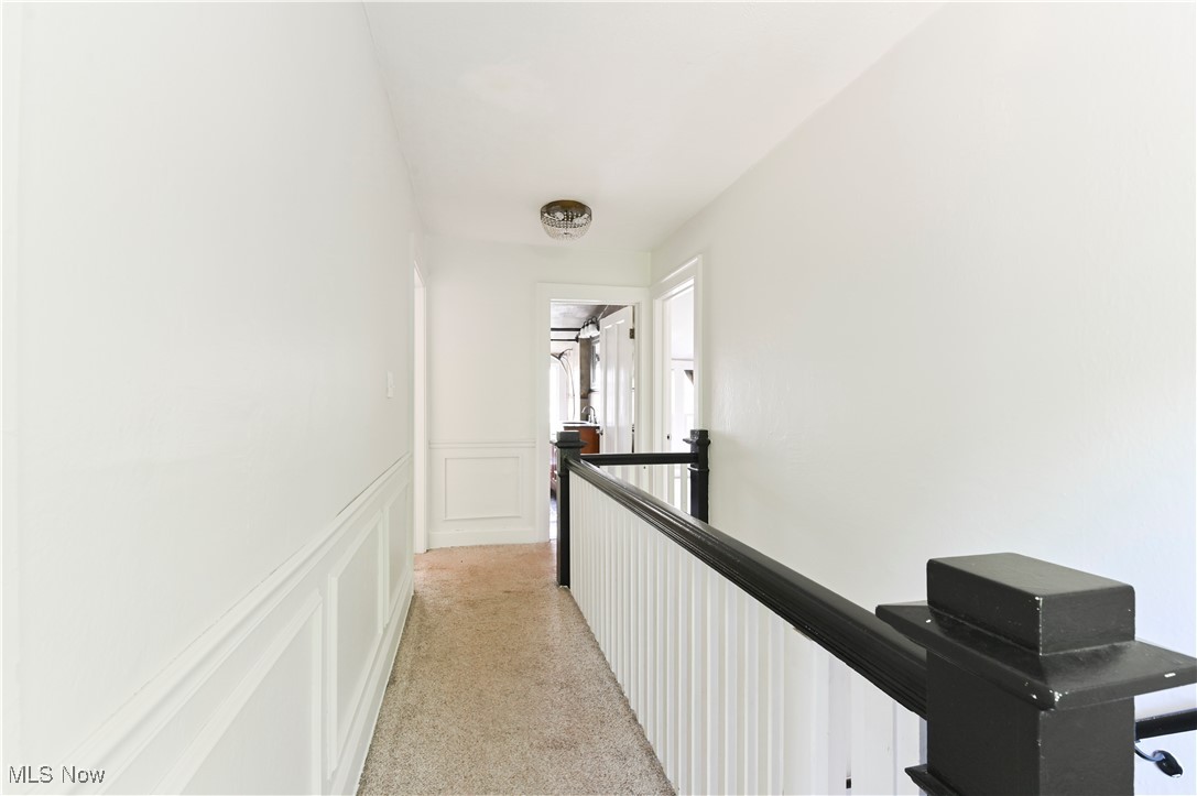 1584 Rydalmount Road Cleveland Heights, OH 44118 - Photo 21 of 36 Hallway with an upstairs landing, a decorative wall, light carpet, and wainscoting