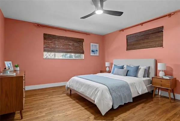 a bedroom with a bed wooden floor and window