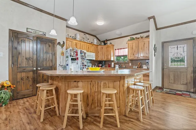 a kitchen with stainless steel appliances granite countertop a stove top oven a sink and a refrigerator