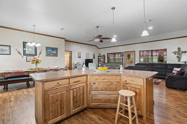 a kitchen that has a lot of cabinets in it and wooden floors