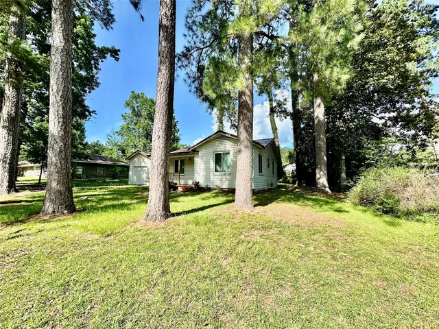 a view of a house with backyard and tree