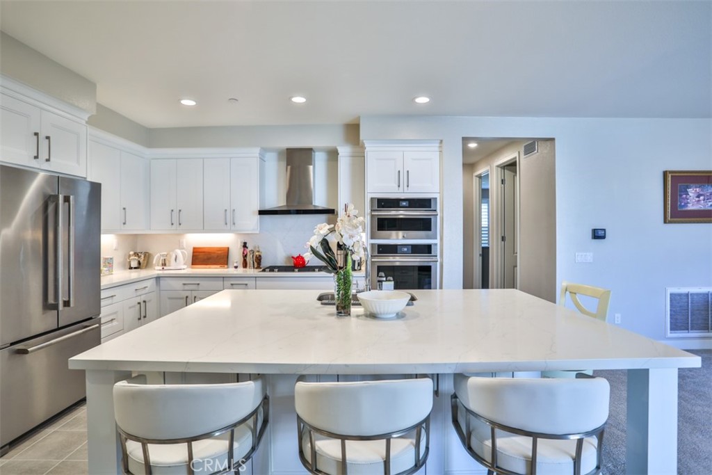 a kitchen with refrigerator and chairs