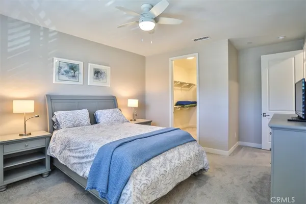 a bedroom with a large bed and flat screen tv
