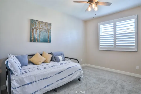 a bedroom with a bed and a chandelier fan