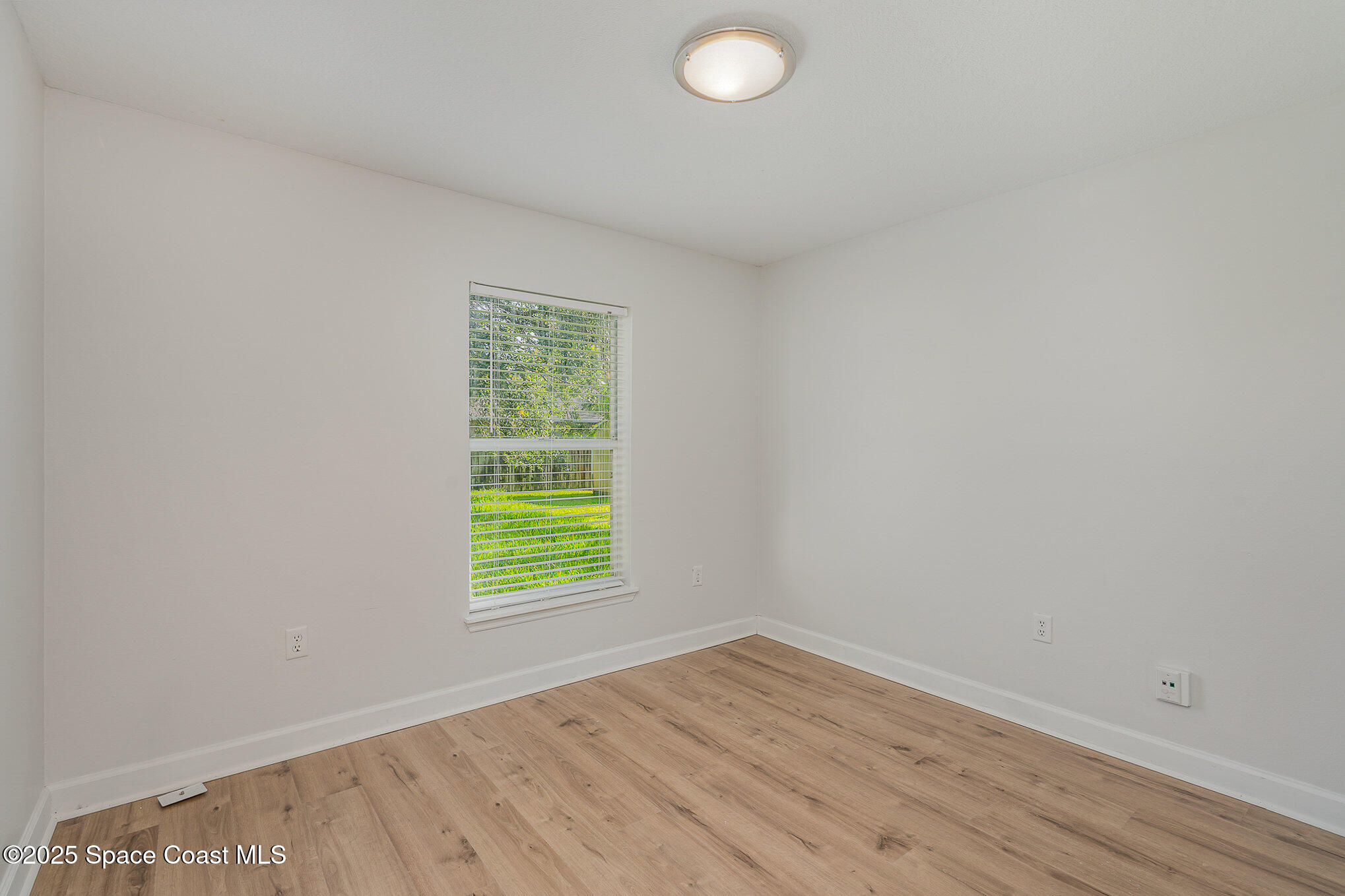 2143 Lansing Street Melbourne, FL 32935 - Photo 17 of 26 an empty room with wooden floor and windows