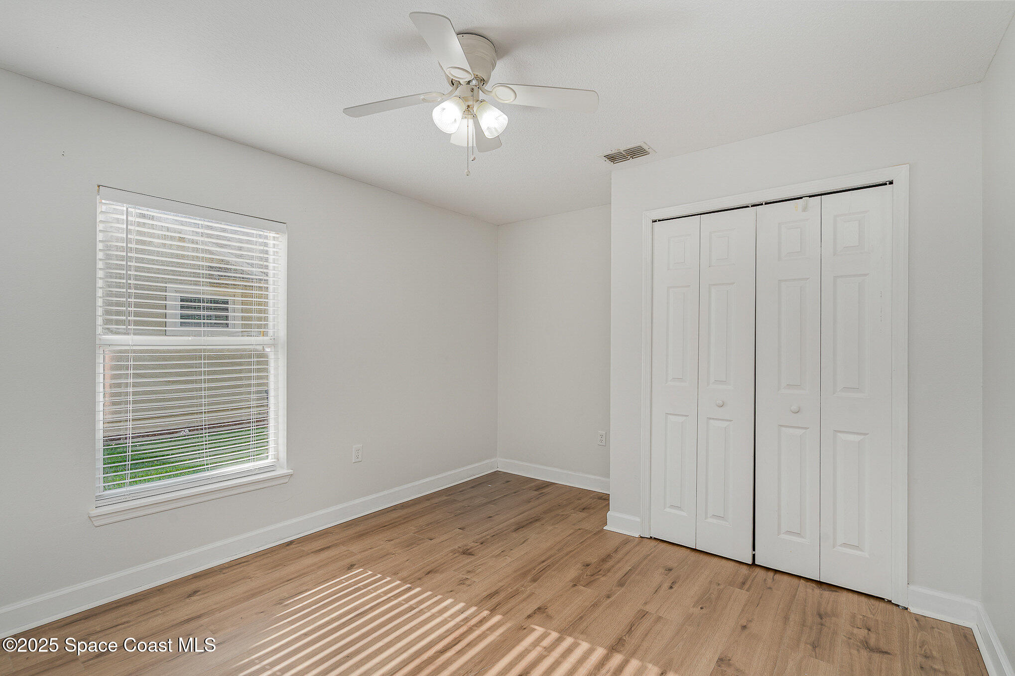 2143 Lansing Street Melbourne, FL 32935 - Photo 19 of 26 a view of an empty room with a window and wooden floor