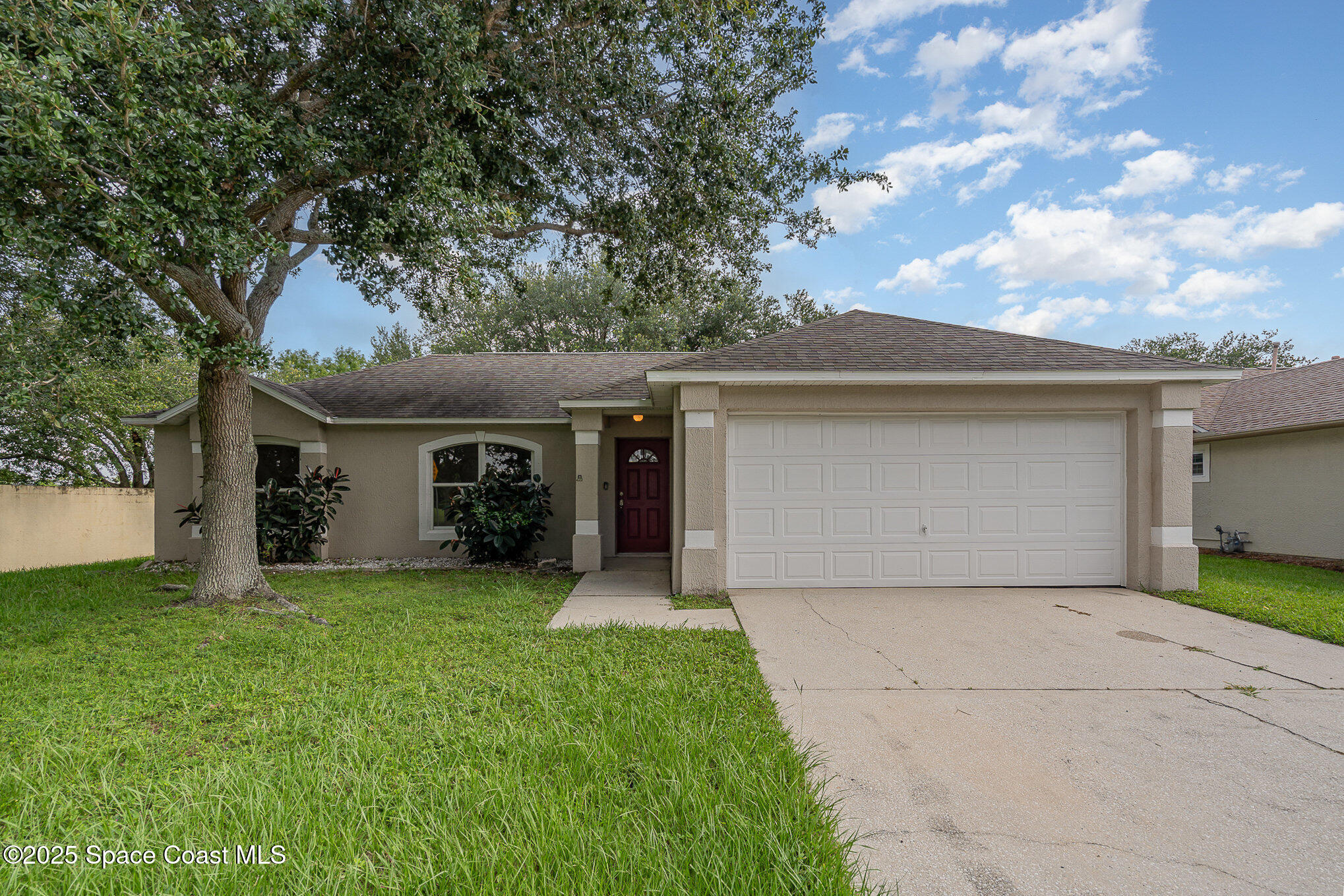 2143 Lansing Street Melbourne, FL 32935 - Photo 2 of 26 a front view of house with yard and trees in the background