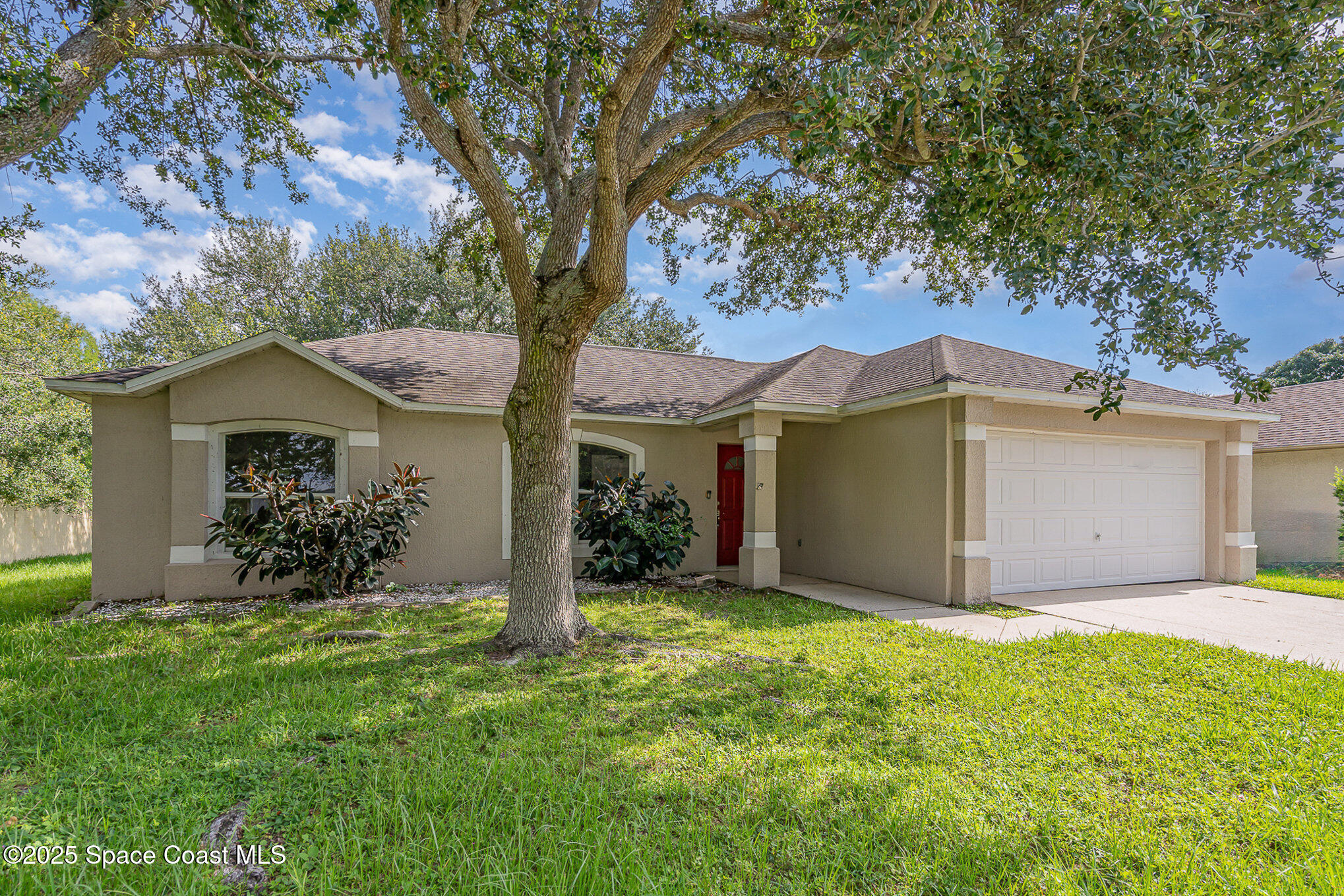 2143 Lansing Street Melbourne, FL 32935 - Photo 3 of 26 a view of a house with a small yard and a large tree
