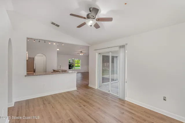 a view of a kitchen with a sink hardwood floor and a ceiling fan