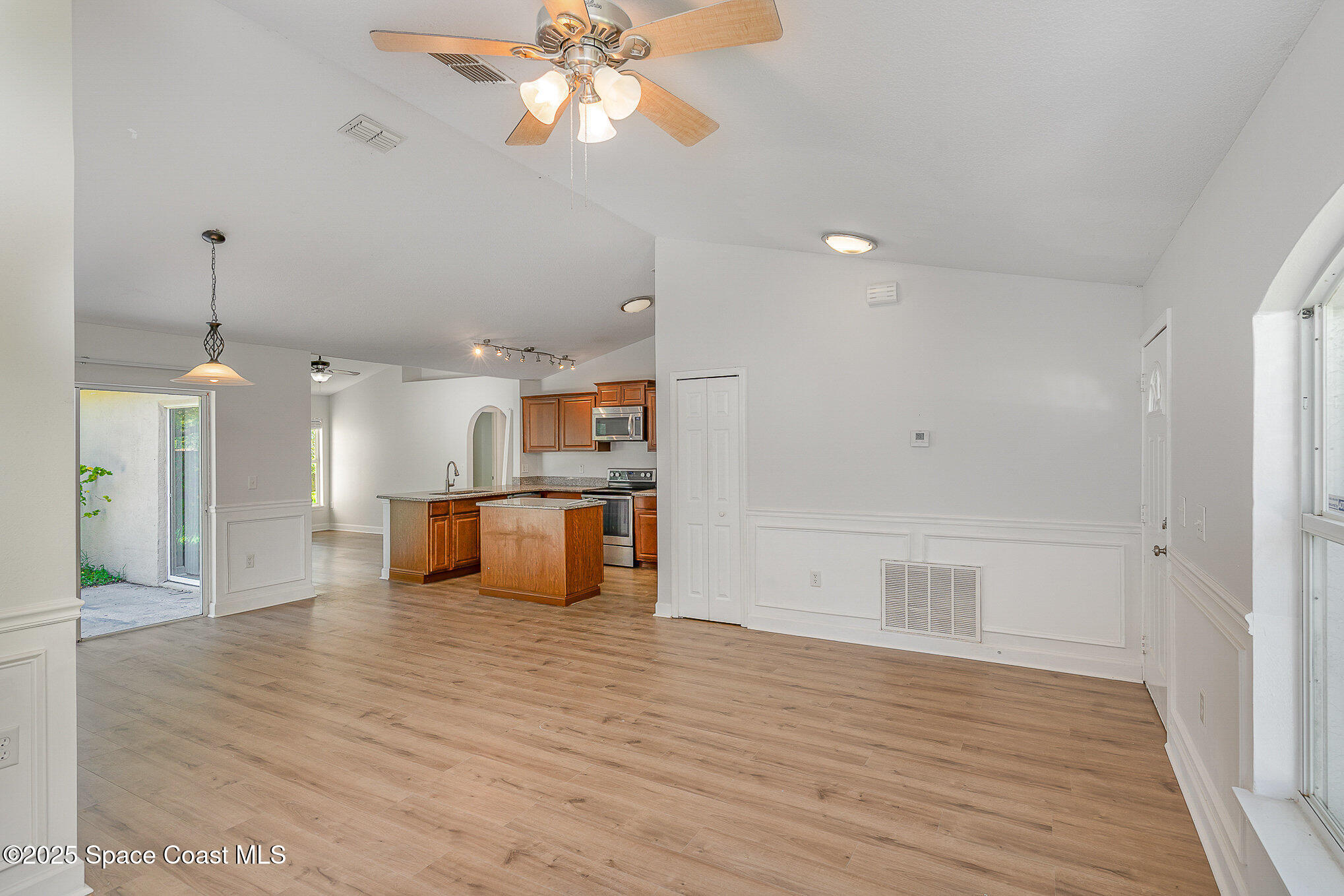 2143 Lansing Street Melbourne, FL 32935 - Photo 7 of 26 a view of a room with wooden floor and a ceiling fan