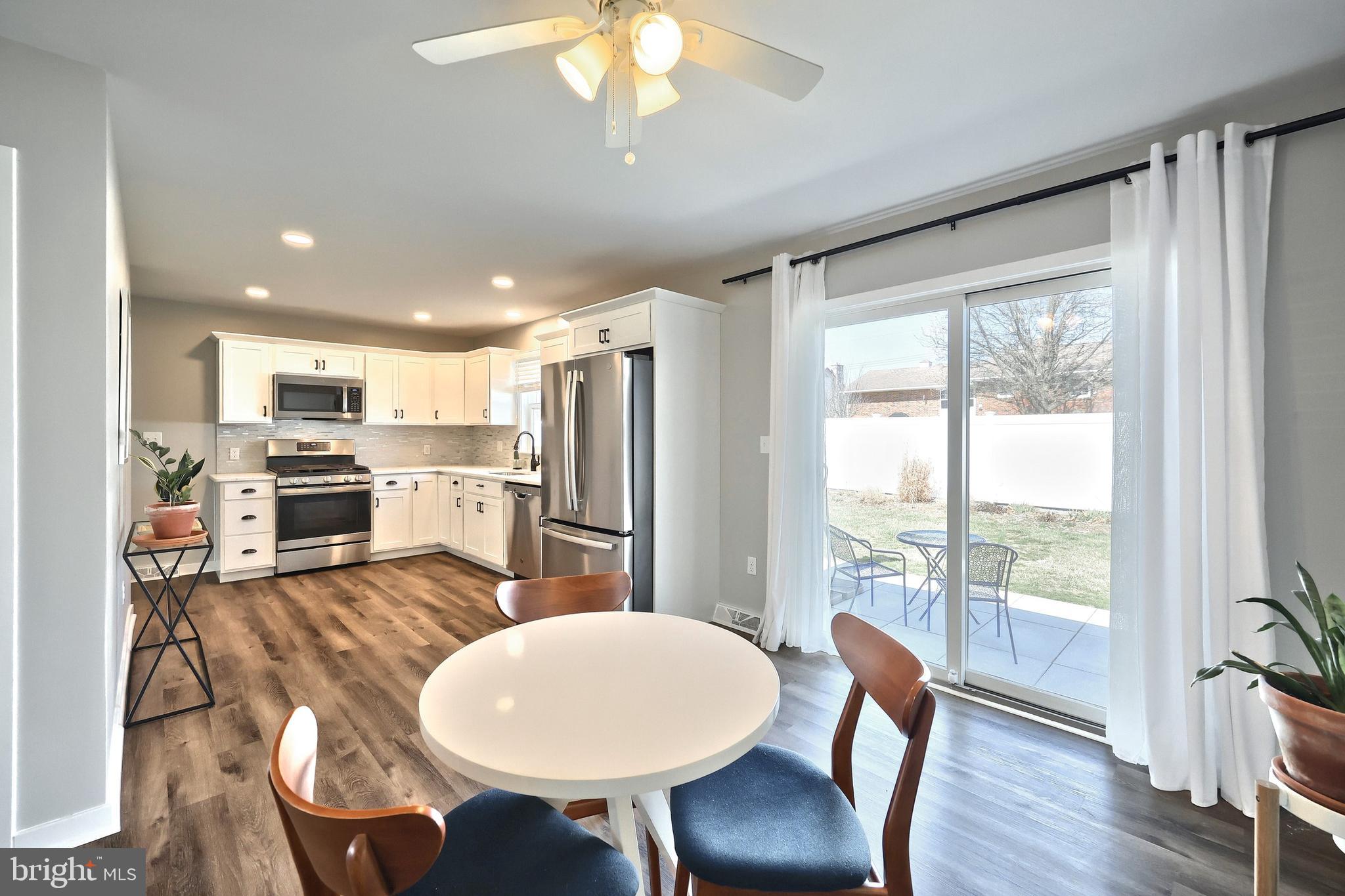 55 Cardinal Drive Hanover, PA 17331 - Photo 23 of 53 a kitchen with stainless steel appliances granite countertop a stove a refrigerator a microwave a dining table and chairs with wooden floor