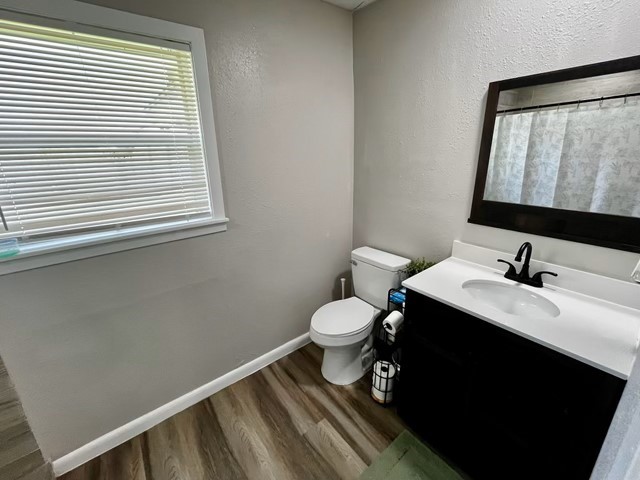 1409 20th Street Huntsville, TX 77340 - Photo 13 of 13 a bathroom with a toilet sink and mirror