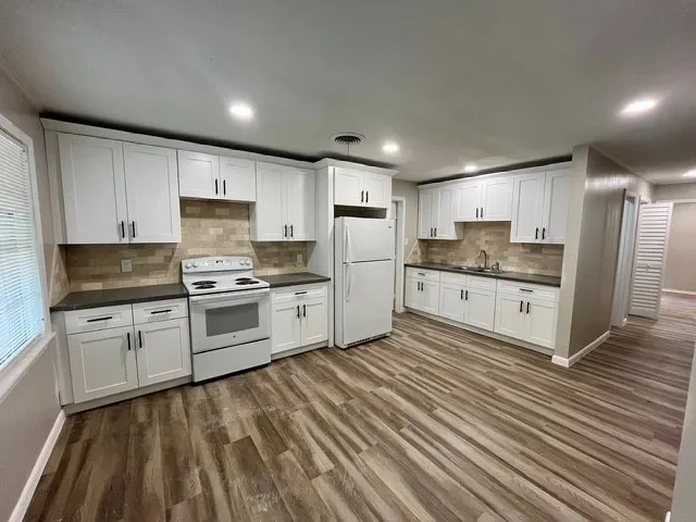 a kitchen with granite countertop white cabinets and stainless steel appliances