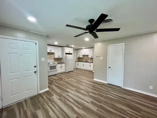 a view of a living room and kitchen with wooden floor