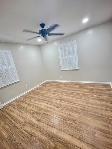 an empty room with a window and ceiling fan