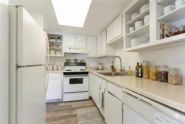 a kitchen with cabinets stainless steel appliances and sink