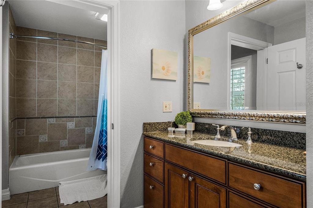 1102 Sunset View Circle, Unit 204 Reunion, FL 34747 - Photo 12 of 26 a bathroom with a granite countertop sink mirror and a bathtub
