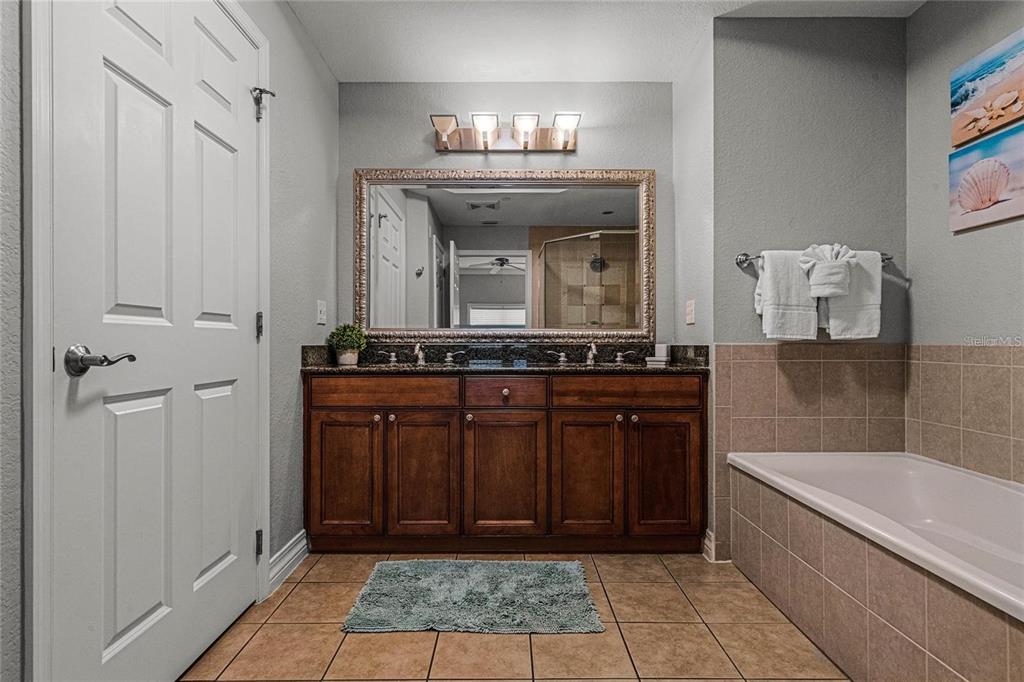 1102 Sunset View Circle, Unit 204 Reunion, FL 34747 - Photo 15 of 26 a bathroom with a granite countertop sink a mirror and bathtub